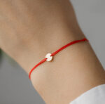Bratara banut mic de aur 14k pe snur rosu martisor